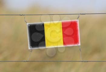 Border fence - Old plastic sign with a flag - Belgium