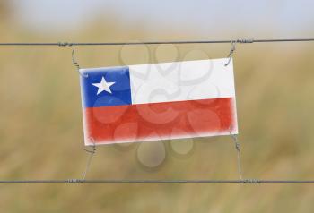 Border fence - Old plastic sign with a flag - Chile
