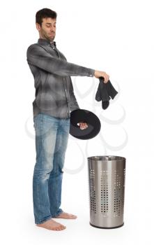 Young man putting a dirty socks in a laundry basket, isolated