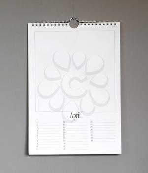 Simple old birthday calendar hanging on a grey wall, copy space - April
