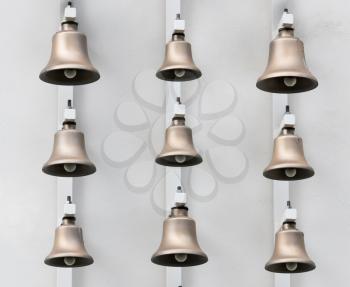 Modern bronze bells on background of white wall