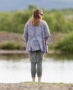 Woman standing at a riverside in Iceland