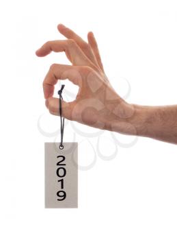 Hand holding a tag, isolated on white - New year - 2019