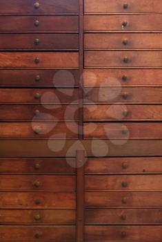 Row of large drawers with empty tags in an old furniture module
