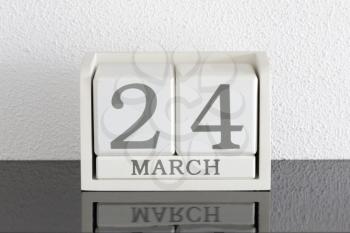 White block calendar present date 24 and month March on white wall background
