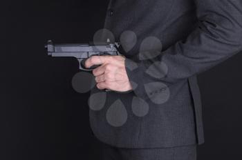 Man in suit with gun, isolated on black