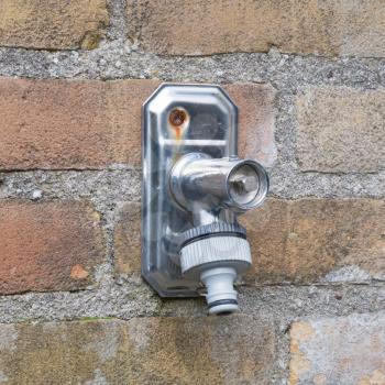 Faucet in a brick wall, selective focus
