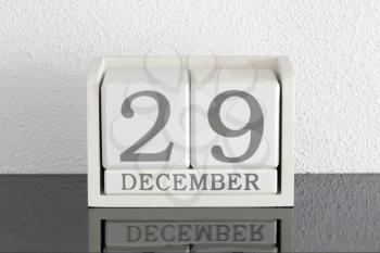 White block calendar present date 29 and month December on white wall background