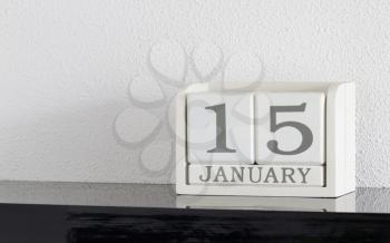 White block calendar present date 15 and month January on white wall background