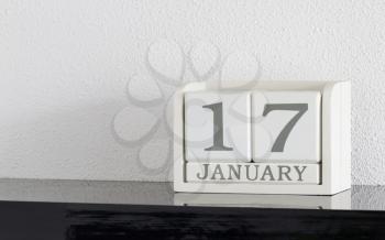 White block calendar present date 17 and month January on white wall background