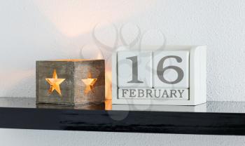White block calendar present date 16 and month February on white wall background
