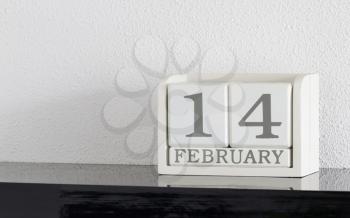 White block calendar present date 14 and month February on white wall background