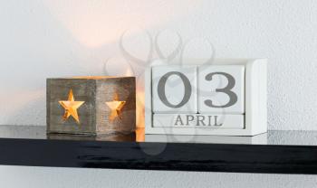 White block calendar present date 3 and month April on white wall background