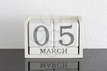 White block calendar present date 5 and month March on white wall background