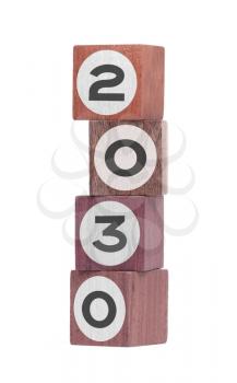 Four isolated hardwood toy blocks on white, saying 2030