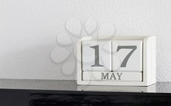 White block calendar present date 17 and month May on white wall background