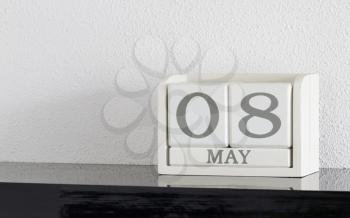 White block calendar present date 8 and month May on white wall background