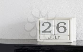 White block calendar present date 26 and month July on white wall background