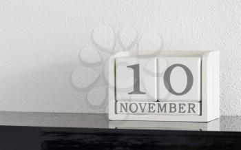 White block calendar present date 10 and month November on white wall background