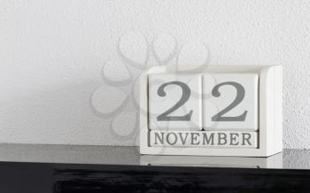 White block calendar present date 22 and month November on white wall background