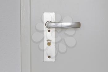 White door with chrome old doorhandle, selective focus