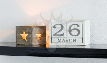 White block calendar present date 26 and month March on white wall background