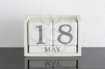 White block calendar present date 18 and month May on white wall background