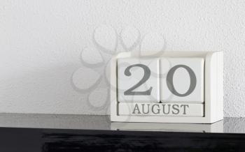White block calendar present date 20 and month August on white wall background