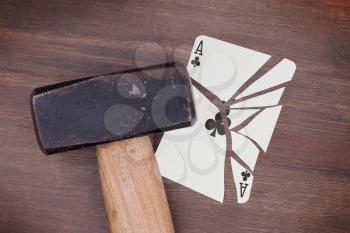 Hammer with a broken card, vintage look, ace of clubs