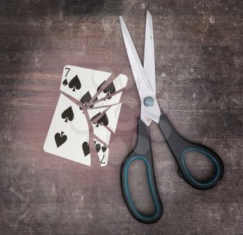 Concept of addiction, card with scissors, seven of spades