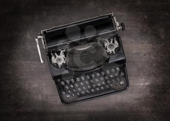 Top view of an old typewriter on a wooden table - dark effect