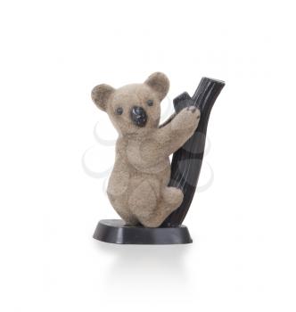 Koala figurine on a branch with white background