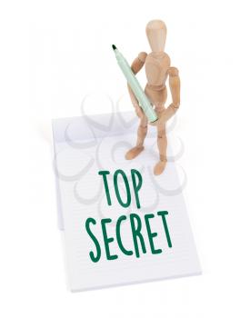 Wooden mannequin writing in a scrapbook - Top secret