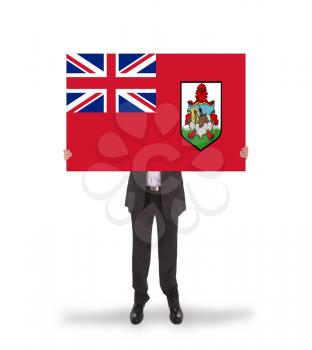Smiling businessman holding a big card, flag of Bermuda, isolated on white