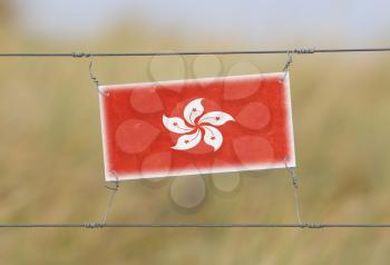 Border fence - Old plastic sign with a flag - Hong Kong