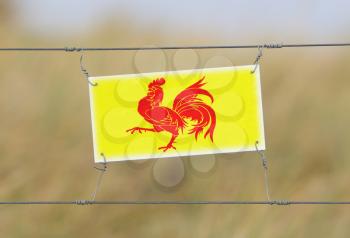 Border fence - Old plastic sign with a flag - Wallonia