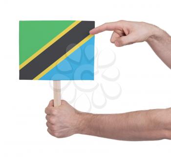 Hand holding small card, isolated on white - Flag of Tanzania