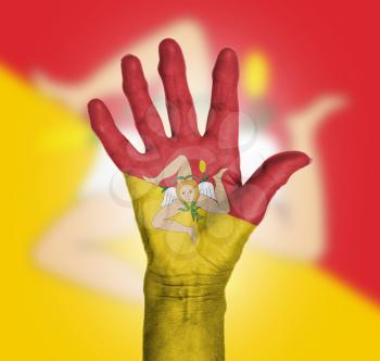 Palm of a woman hand, painted with flag of Sicily