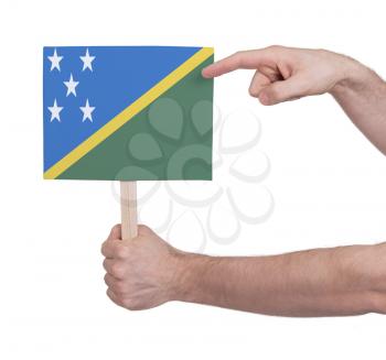 Hand holding small card, isolated on white - Flag of Solomon Islands