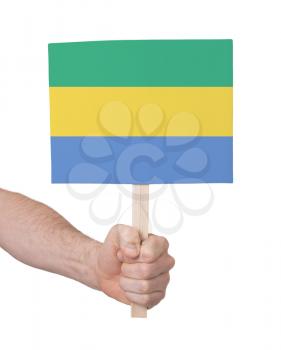 Hand holding small card, isolated on white - Flag of Gabon