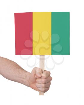 Hand holding small card, isolated on white - Flag of Guinea
