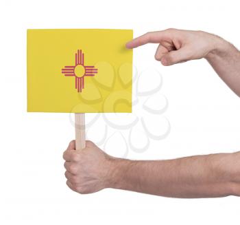 Hand holding small card, isolated on white - Flag of New Mexico