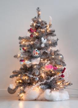Isolated decorated christmas tree, silver tree with a white wall