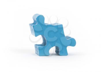 Closeup of big blue jigsaw puzzle piece isolated on white