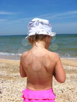 The back of little girl standing near the sea