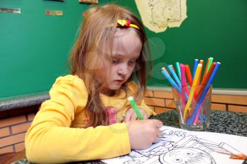 image of little girl draws the drawing at the table