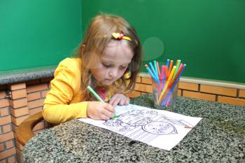 image of little girl drawing at the table
