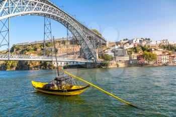 Traditional boats with wine barrels and Douro River in Porto in a beautiful summer day, Portugal