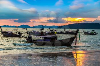Traditional long tail boat at sunset on Ao Nang beach, Thailand in a summer day