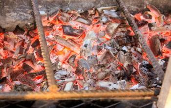 BBQ with Hot Coals for Cooking Meat.  Charcoal fire grill. Barbecue embers glowing in red fire.